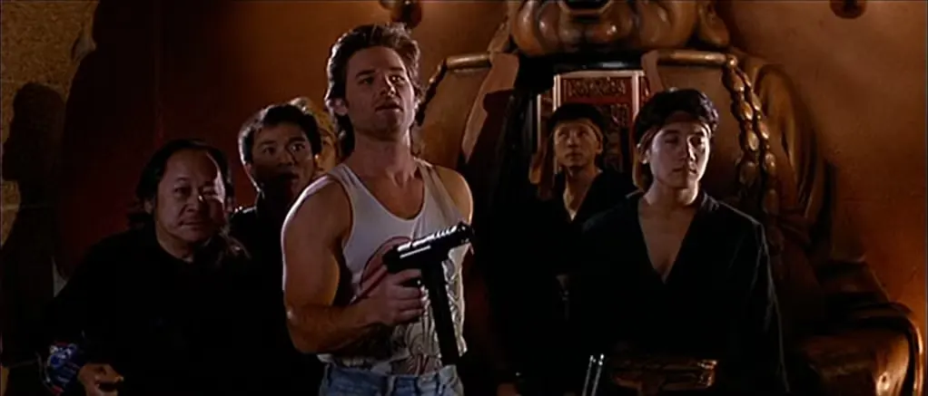 Kurt Russell holds a submachine gun in Big Trouble in Little China.