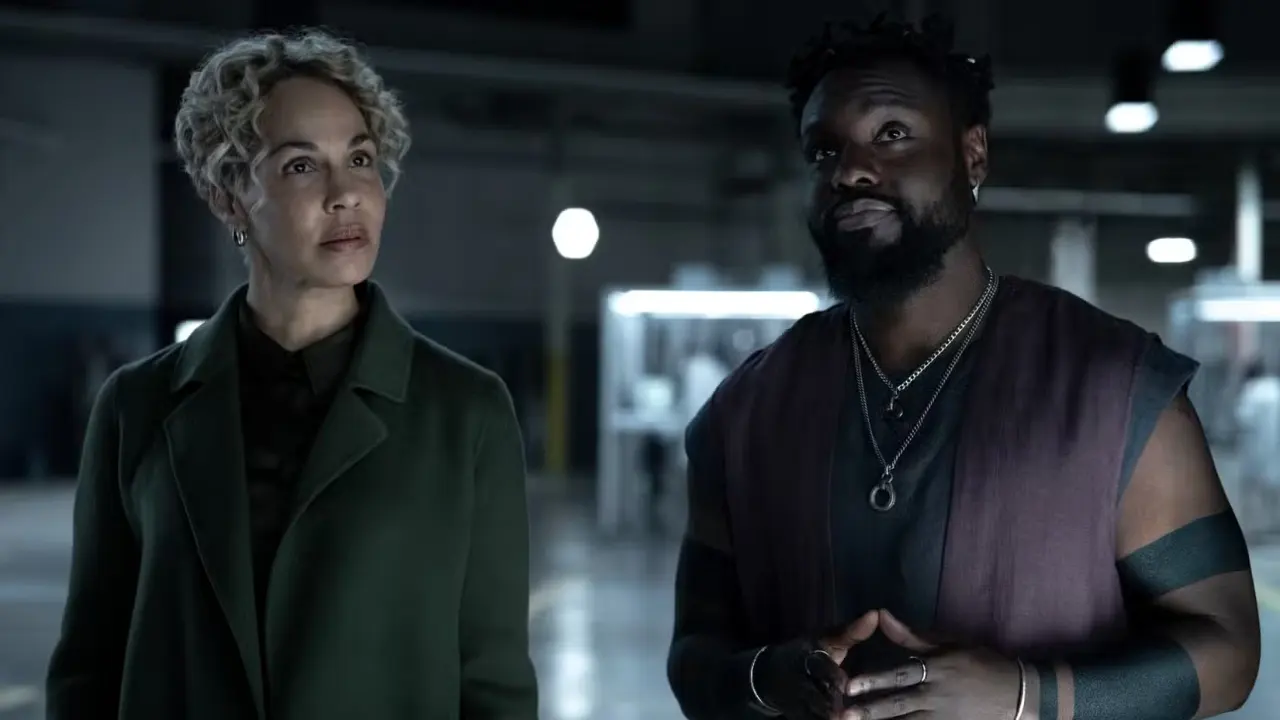 Blair Caplan (Amanda Brugel) stands next to a version of Leighton Vance (Dayo Okeniyi) in Velocity Labs in Dark Matter season 2.